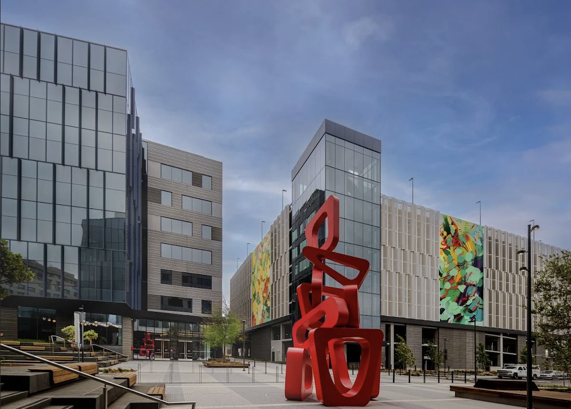The Landing Life Sciences Campus: glass-fronted lab buildings around an open plaza with a red sculpture.